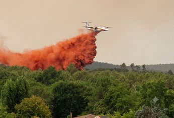 Un avión hidrante arroja agua mientras combate incendios forestales en la región de Lège-Cap-Ferret.