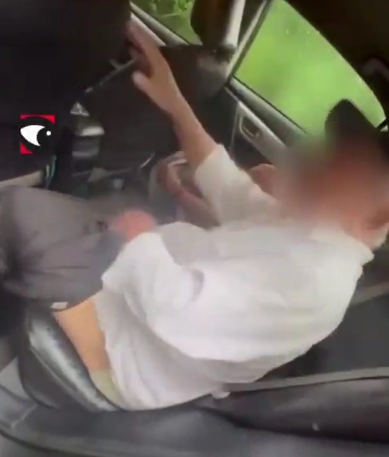 El taxista junto a la menor de edad acomodándose la ropa en el asiento trasero de su auto.