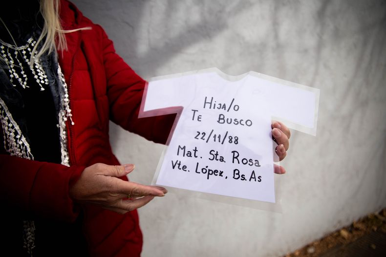 &nbsp;Las manos de Liliana Leiva sujetan un cartel en forma de bata de beb&eacute; en la que se leen los datos de nacimiento de su hijo.