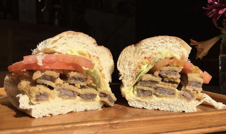 El sandwich tucumano se arma con un pan especial para no dañar el paladar. Además, tanto la lechuga como la milanesa están cortadas en tiras, lleva también tomates frescos cortados bien finitos en rodajas, mayonesa, mostaza y salsa de ají para darle ese toque final.