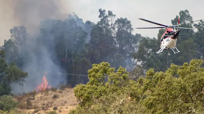 Medios aéreos trabajan en las labores de extinción del incendio que se desató el pasado martes en El Cerro del Andévalo. Agencia EFE