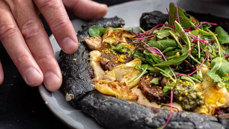 Tienen una increíble pizza veggie con carbón activado.