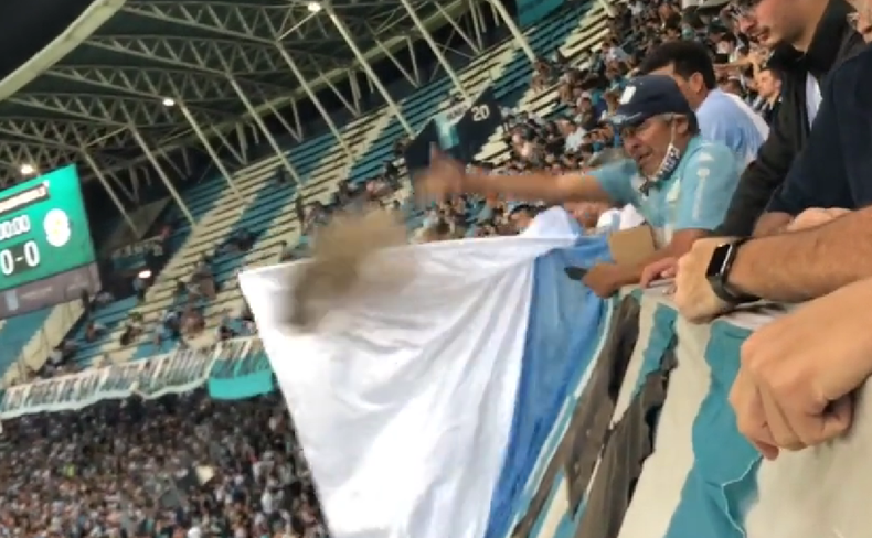 El hincha de Racing tirando cenizas durante la victoria contra Argentinos.
