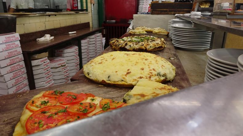 La abundancia de ingredientes es clave en la pizza porteña.
