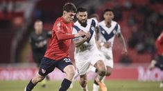 Santiago López, del Rojo, se escapa de la marca de los jugadores del Fortín. Santiago López, del Rojo, se escapa de la marca de los jugadores del Fortín.