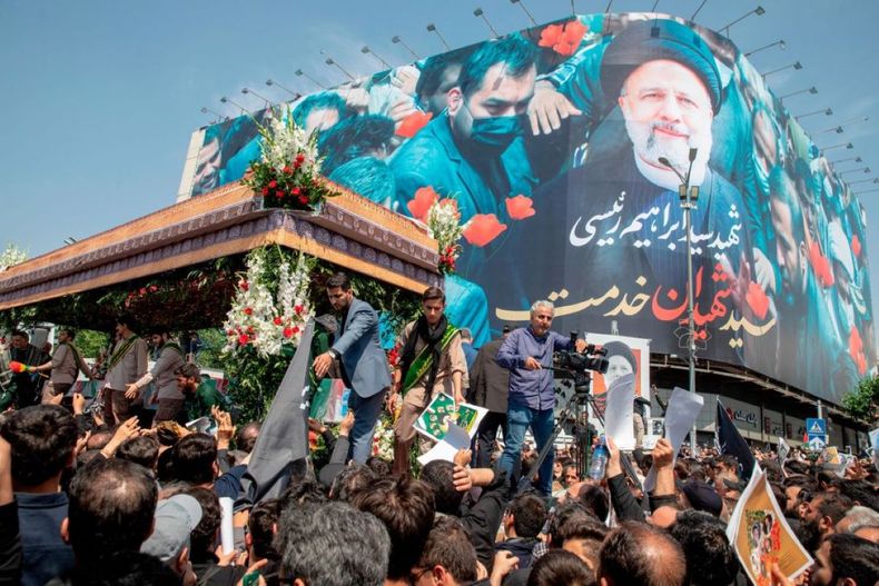 Iraníes siguen a un camión que transporta los ataúdes del difunto presidente Ebrahim Raisi y sus acompañantes durante una ceremonia fúnebre en Teherán