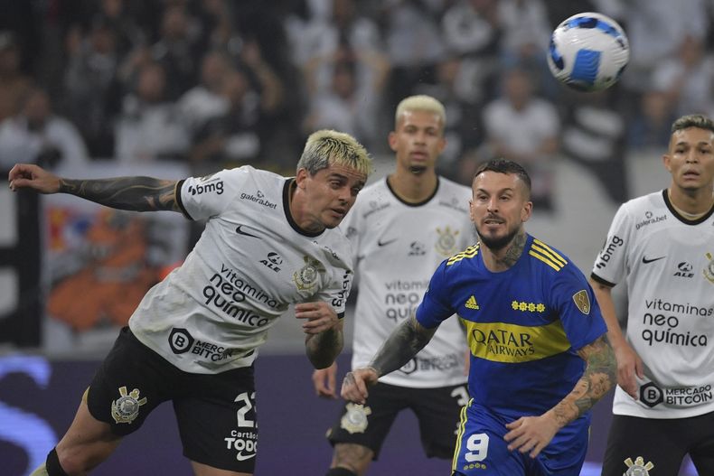 El defensor Fagner rechaza ante la mirada de Benedetto.