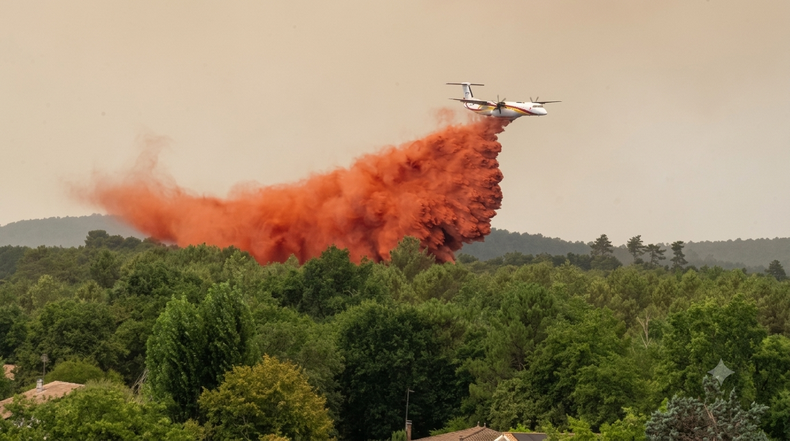 Un avión hidrante arroja agua mientras combate incendios forestales en la región de Lège-Cap-Ferret.