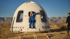 La mujer se dirigió desde su silla de ruedas hacia la cápsula utilizando un banco que se extendía desde la escotilla. La mujer se dirigió desde su silla de ruedas hacia la cápsula utilizando un banco que se extendía desde la escotilla.