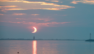Eclipse solar parcial mientras el Sol sale detrás del Faro del Rompeolas de Delaware,&nbsp; el 10 de junio de 2021.