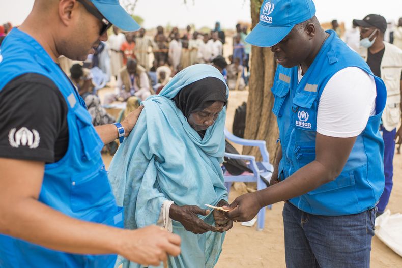 Khadija, mujer sudanesa refugiada, es asistida por trabajadores de ACNUR, la Agencia de la ONU para los refugiados. 