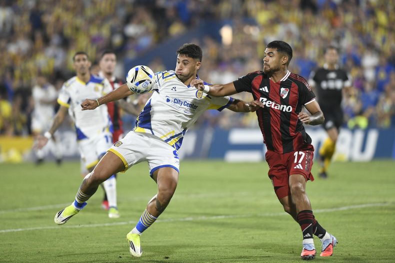 Alejo Veliz intenta cubrir la pelota ante la marca de Paulo Díaz.