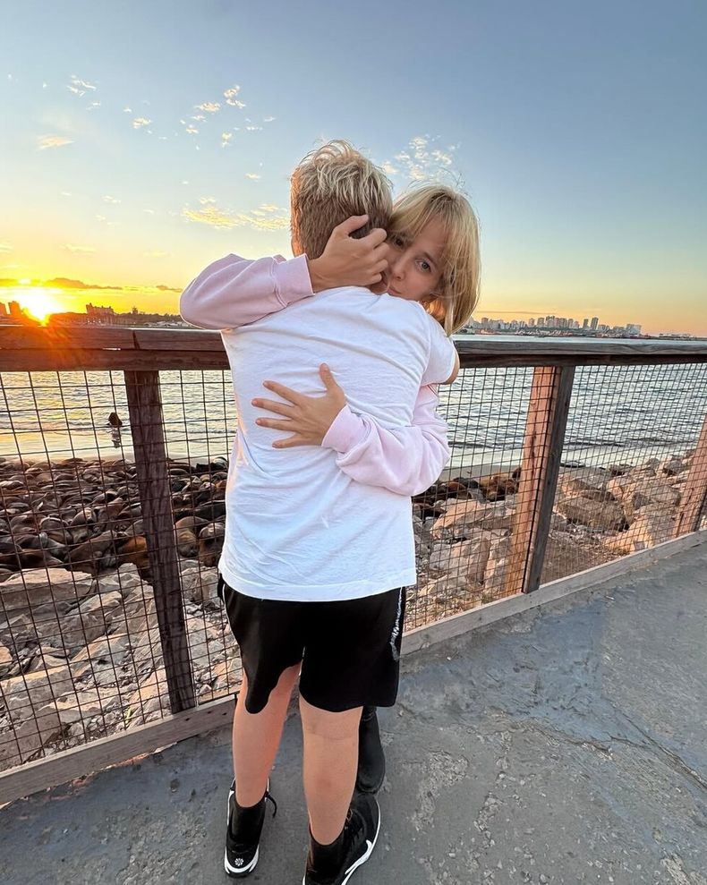 Noah, de espalda, se abraza con su madre.