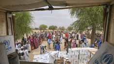 Trabajadores de Acnur descargan kits con asistencia de emergencia para distribuirlos a los refugiados sudaneses recién llegados al campamento de Madjigilta, en la región de Ouaddaï de Chad.