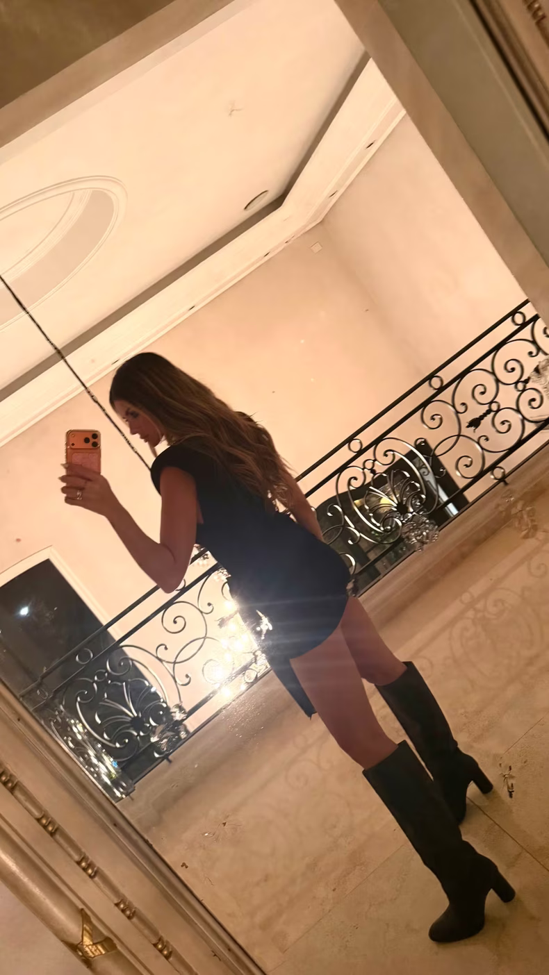 Look total black, con un vestido corto y botas de caña alta como protagonistas.