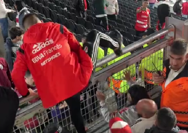 Uno de los hinchas trepando para dejar el lugar.