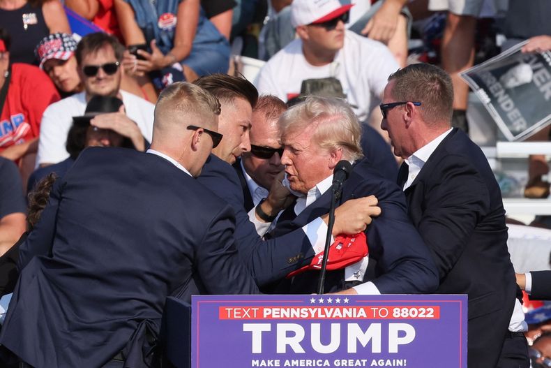 Donald Trump es asistido luego de ser atacado por un francotirador.