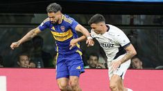 Milton Giménez, de Boca, disputa el balón con Adrián Spörle, del Rojo. Milton Giménez, de Boca, disputa el balón con Adrián Spörle, del Rojo.