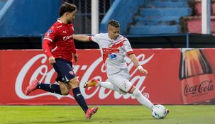 El chileno Felipe Loyola, del Rojo, marca a Johan Bocanegra.