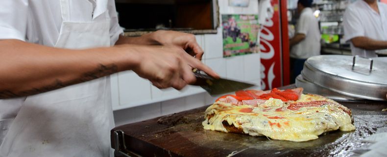 El hipnotizante trajín diario de una ajetreada pizzería porteña.