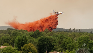 Un avión hidrante arroja agua mientras combate incendios forestales en la región de Lège-Cap-Ferret.