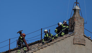 Los trabajadores del Vaticano instalan la chimenea.
