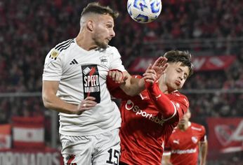 Nicolás Sansotre, defensor de Riestra, rechaza el balón ante el cruce de Diego Tarzia.